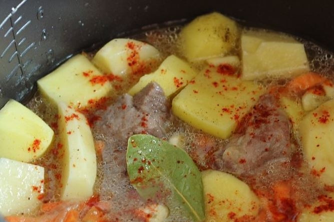 1. Этап. Тушеный картофель со свининой: Залейте все водой, добавьте паприку. Поставьте мультиварку в режим тушения и готовьте блюдо около часа. Подавайте его горячим.