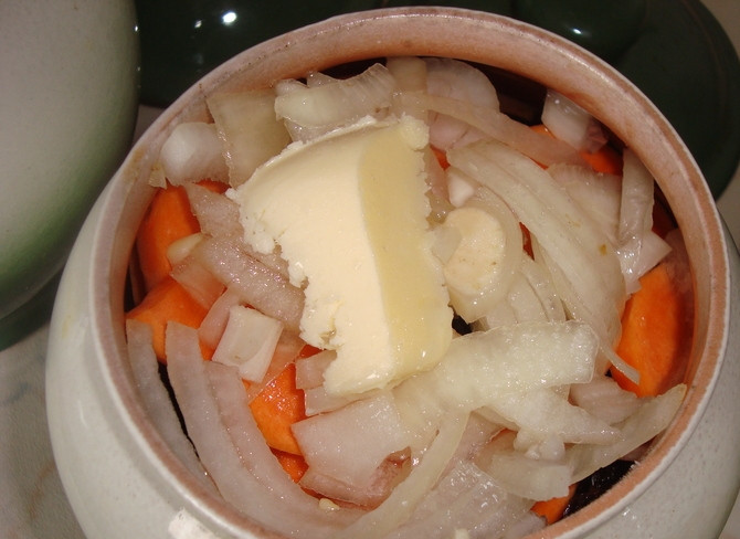 1. Этап. Мясо с черносливом в горшочках: В каждый горшочек сверху положить кусочек сливочного масла и всё залить водой на 2/3 горшочка.