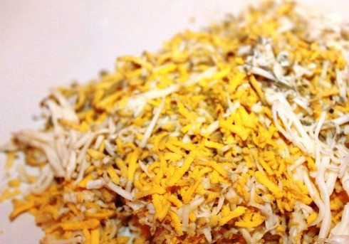 1. Этап. Салат в шариках с рисом и консервой: Натрите яйца и морковь.