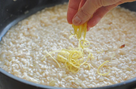 1. Этап. Ризотто с кабачками и помидорами: Когда рис будет готов наполовину, в него следует добавить лимонную цедру.