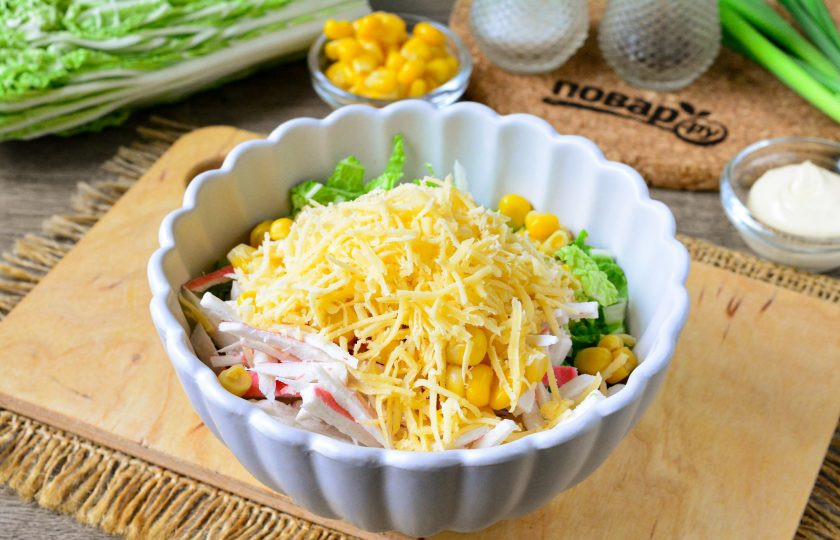 1. Этап. Салат с сыром, крабовыми палочками и пекинской капустой: Твердый сыр натрите на средней или крупной терке и всыпьте его в салат.