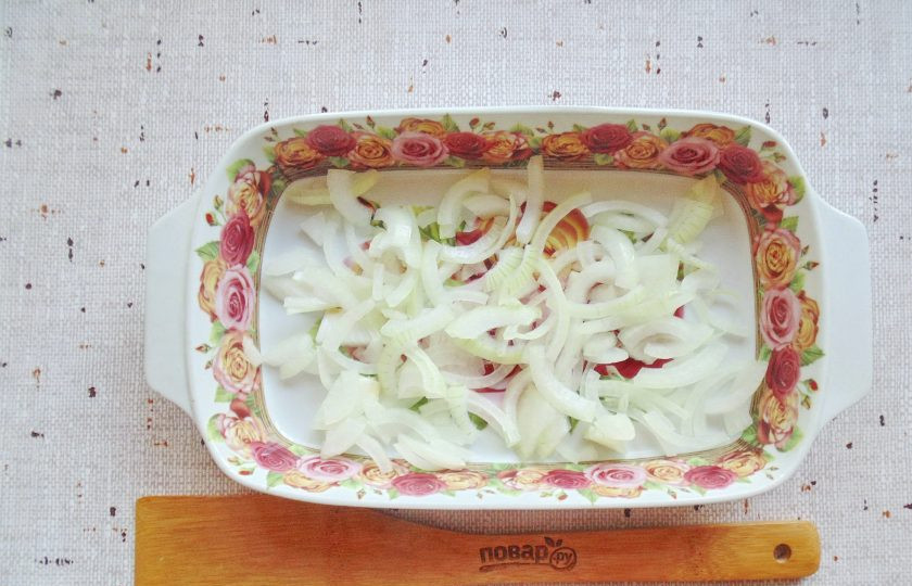 1. Этап. Карась в духовке на луковой подушке: Лук очистите, ополосните и нарежьте полукольцами. Выложите в форму для запекания, равномерно распределите по дну.