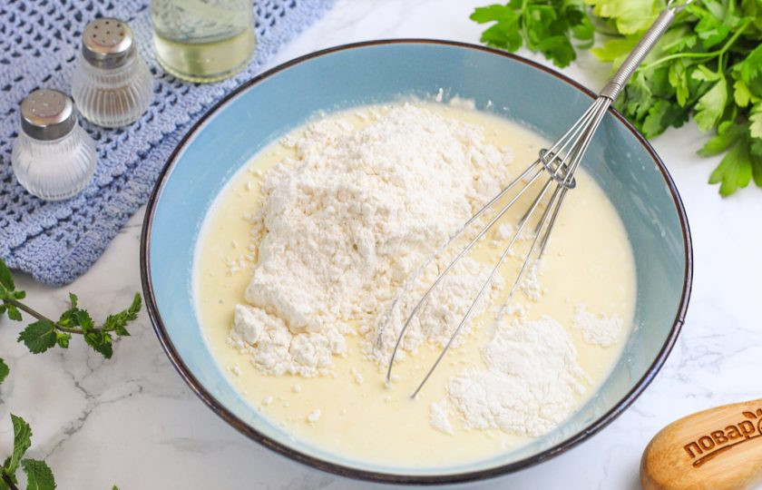 1. Этап. Пирог с солеными грибами: Влейте растительное масло, перемешайте и всыпьте по частям пшеничную муку высшего сорта и разрыхлитель. Вмешайте их в массу.