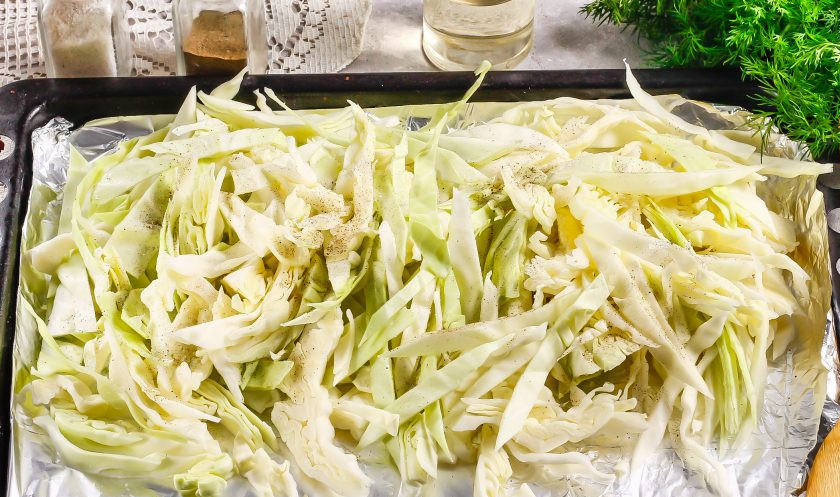 1. Этап. Запеченный карп в духовке с капустой: Застелите противень фольгой или пергаментной бумагой и выложите на него капустную нарезку, распределите равномерно.