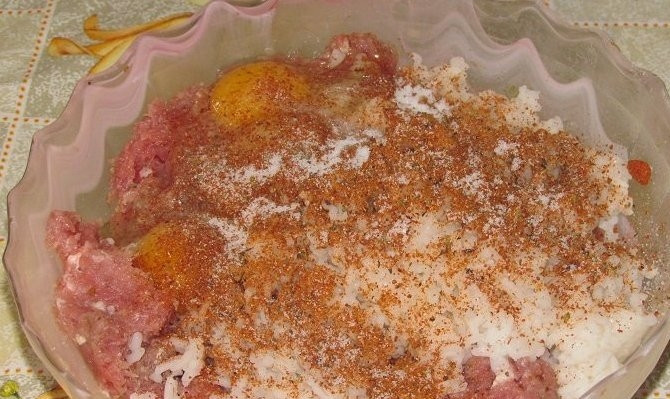 1. Этап. Тефтели с подливой в духовке: Добавляем яйца и по одной чайной ложке соли, перца и специй для мяса.