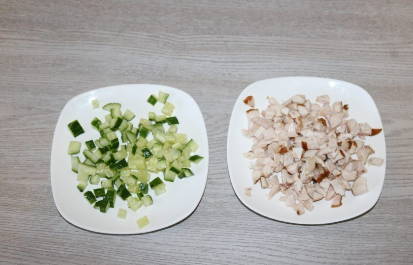 1. Этап. Салат с корейской морковкой, курицей и яйцом: Огурец и куриную грудку нарежьте кубиками. Яйца куриные натрите на крупной тёрке. Сыр натрите на мелкой тёрке.