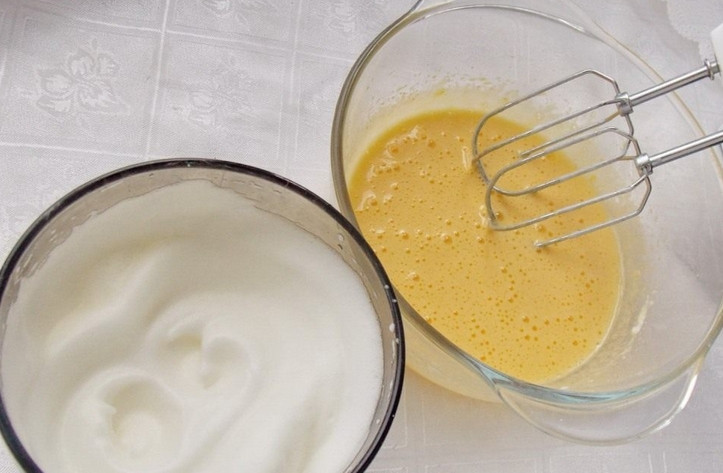 1. Этап. Пышный бисквит: Используем яйца исключительно комнатной температуры. Отделяем желтки от белков. В эмалированную емкость кладем желтки, тщательно взбиваем миксером, чтобы консистенция была, как у сметаны. Отдельно, на маленькой скорости взбейте белки до крепкой пены.