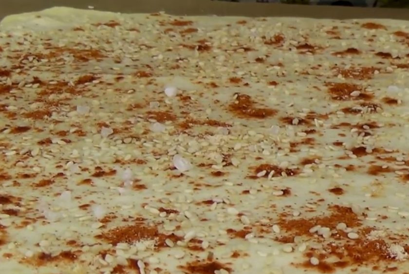 1. Этап. Лаваш-крекер: 4. Смажьте пласт водой при помощи кисточки, посыпьте паприкой, морской солью, чесноком, семечками подсолнечника, тыквы и кунжутом. Аккуратно, слегка придавливая, пройдитесь по лавашу скалкой. Разрежьте лаваш на квадраты.