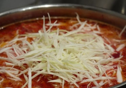 1. Этап. Вкусный борщ с говядиной: Вливаем заправку в бульон, досаливаем и варим около 15 минут. Высыпаем в борщ мелко нашинкованную капусту.