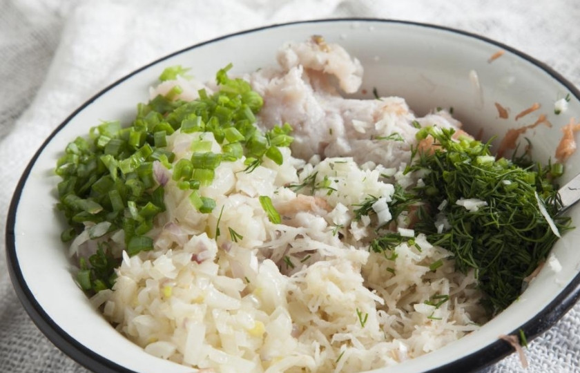 1. Этап. Котлеты из сома без запаха: Лук мелко порежьте и обжарьте. Картошку сырую натрите на терке и сбрызните соком лимона. Добавьте к рыбе обжаренный лук, измельченный чеснок, картошку, рубленную зелень и зеленый лук. Посолите и поперчите, перемешайте.