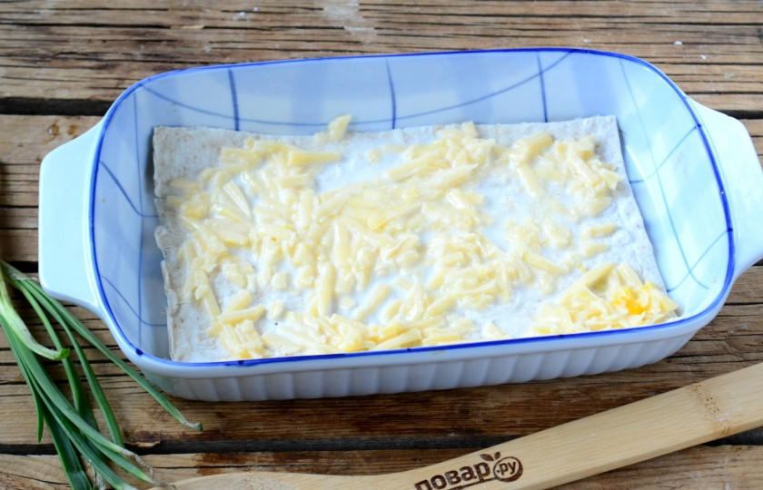 1. Этап. Сырный пирог из армянского лаваша: Дно формы смажьте сливочным маслом и положите первый лист лаваша. Положите на него ¼ всей начинки и разравняйте. Сверху накройте вторым листом лаваша и повторите процедуру. Обратите внимание, у нас получится 5 листов лаваша и 4 слоя сырной начинки. Верхний лист лаваша можно смазать взбитым яйцом, а можно оставить и так.