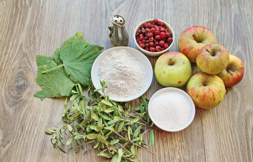 1. Этап. Моченые яблоки с брусникой: Подготовьте все необходимые ингредиенты для приготовления моченых яблок с брусникой. Ягоды переберите, удаляя мятые и испорченные. Яблоки, листья и ягоды вымойте в горячей воде.