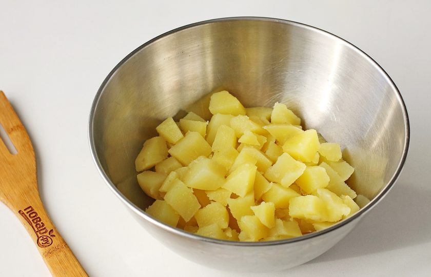 1. Этап. Постный Оливье с грибами: Картофель очистите, нарежьте кубиками и переложите в глубокую миску.