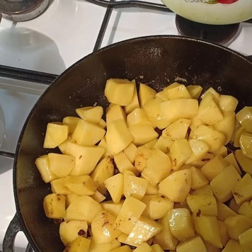 1. Этап. Картошка с мясом в духовке: На сковороду выложить картофель и обжарить его на растительном масле до появления золотистой корочки, а затем переложить в миску.