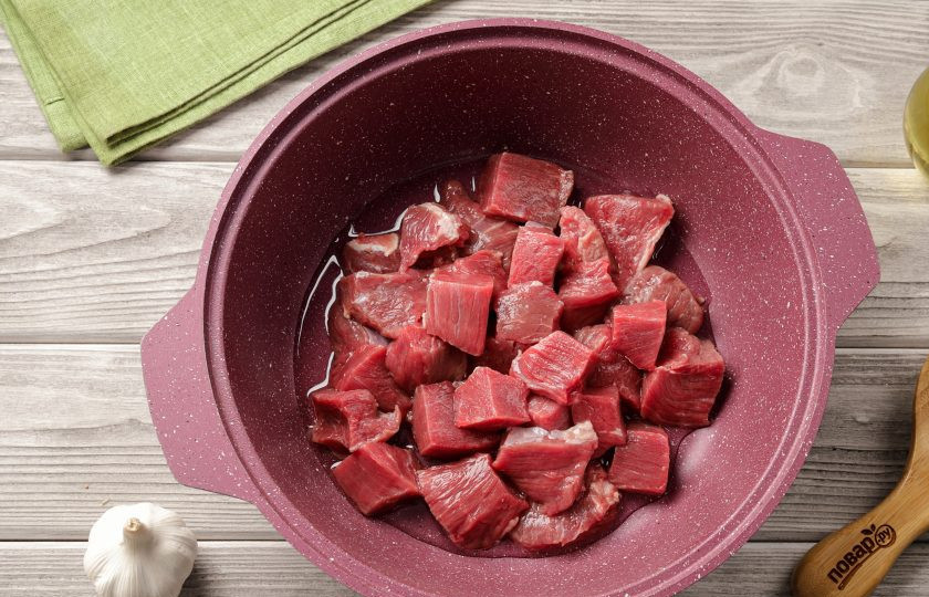 1. Этап. Тушёная картошка с мясом и баклажанами: Для приготовления возьмите казан или глубокую сковороду с толстым дном. Налейте масло, разогрейте его и выложите нарезанное мясо.