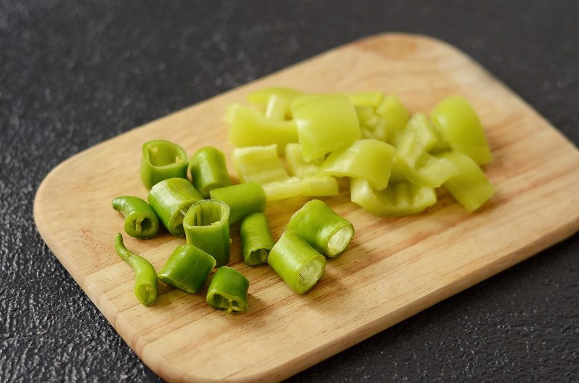 1. Этап. Лечо из горького перца: Острый перец нарежьте на 3-4 части, удалите из трубочек семена. Сладкий перец тоже очистите от семян, затем нарежьте на ломтики среднего размера.