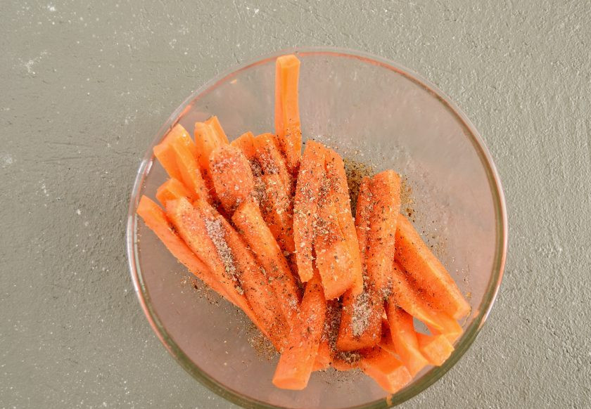 1. Этап. Морковные палочки: Посыпьте сверху специями и солью. Перемешайте так, чтобы полностью покрыть ими морковь.