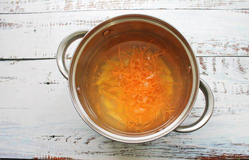 1. Этап. Дачный рисовый суп со снытью: Морковь почистите, натрите на средней терке и добавьте в кастрюлю. Варите все в течение 10 минут на среднем огне.