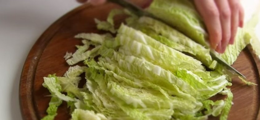 1. Этап. Салат Цезарь с курицей по-домашнему: 3. Добавьте несколько целых зубчиков чеснока, сбрызните растительным маслом и отправьте в разогретую духовку. Подсушите хлеб, периодически помешивая его лопаткой. Пекинскую капусту нарежьте тонкими полосками, куриную грудку – кубиками.