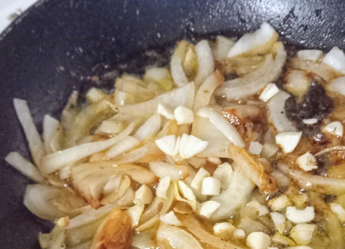 1. Этап. Яйца по-малазийски: Убавить огонь до ниже среднего. В той же сковороде разогреть оставшееся масло, добавить лук и готовить его 7 минут. Затем добавить чеснок и красный жгучий перец. Готовить ещё минуту.