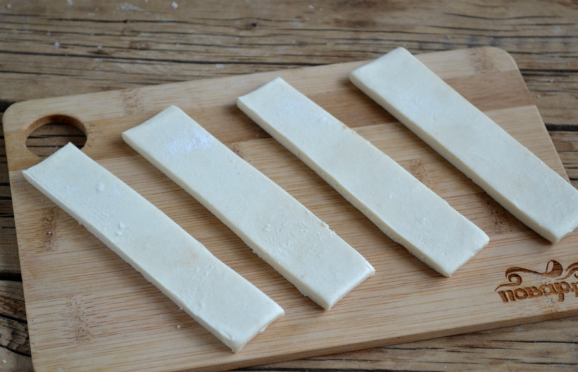 1. Этап. Булочки с корицей из слоеного теста: Тесто порежьте на полоски шириной около 2 см. Посыпьте их смесью корицы и сахара.