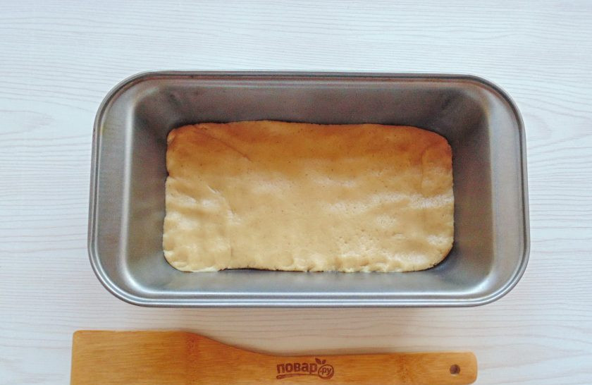 1. Этап. Коврижка с абрикосами: Одну треть теста выложите в форму для выпекания с пекарской бумагой. Распределите тесто по дну формы.