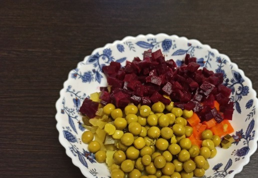 1. Этап. Овощной салат с сырно-чесночной заправкой: Свёклу нарезать кубиками. Всё соединить в салатнике. Добавить вкусный консервированный горошек.