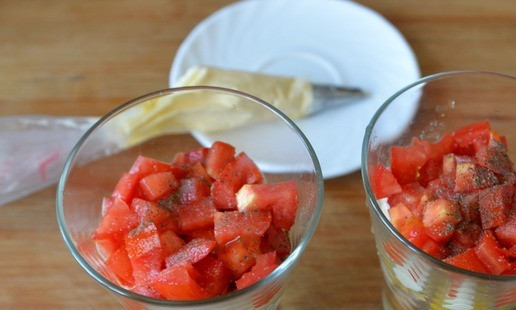 1. Этап. Салат Восторг: Помидоры режем кубиками. Если они слишком сочные внутри, то срезаем мякоть. Кладём порезанные помидоры сверху кукурузы, слегка солим, перчим, наносим слой майонеза с чесноком.