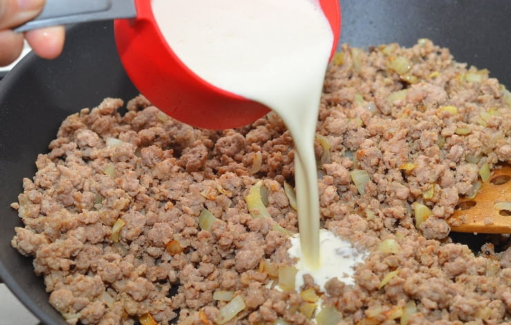 1. Этап. Соус Болоньезе долмио: Добавляем к луку и чесноку мясной фарш и сливки. Перемешиваем и тушим под закрытой крышкой около десяти минут.