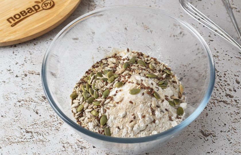 1. Этап. Ржано-пшеничный хлеб с семечками: Смешайте в миске оба вида муки, семечки, соль, сахар и сухие дрожжи.