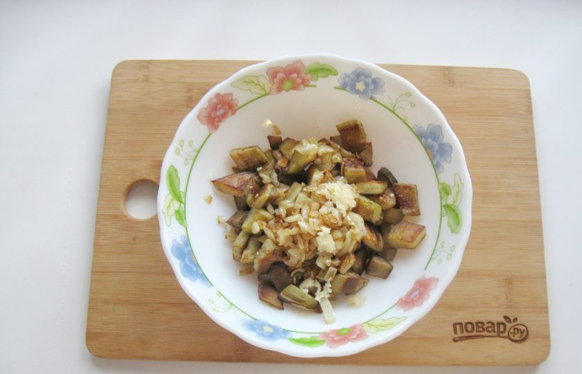 1. Этап. Баклажаны как грибы с майонезом: Чеснок измельчите любым способом и выложите в салатник с баклажанами и луком.