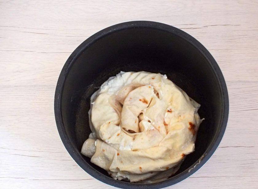 1. Этап. Лаваш с творогом в мультиварке: Возьмите чашу мультиварки и смажьте дно тонким слоем масла. Выложите 