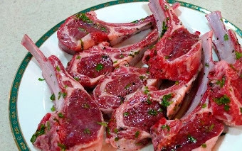 1. Этап. Баранья корейка на кости: Промываем баранью корейку. Перекладываем её на доску и разделываем. Нужно разрезать её, отделив ребра друг от друга. Нарезаем зелень. Растираем баранину солью и перцем. Посыпаем зеленью.