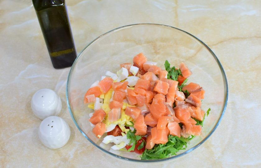 1. Этап. Салат с семгой и кукурузой: Рыбу нарежьте небольшими кубиками. Заправьте салат оливковым маслом. По вкусу посыпьте солью и специями. Перемешайте.