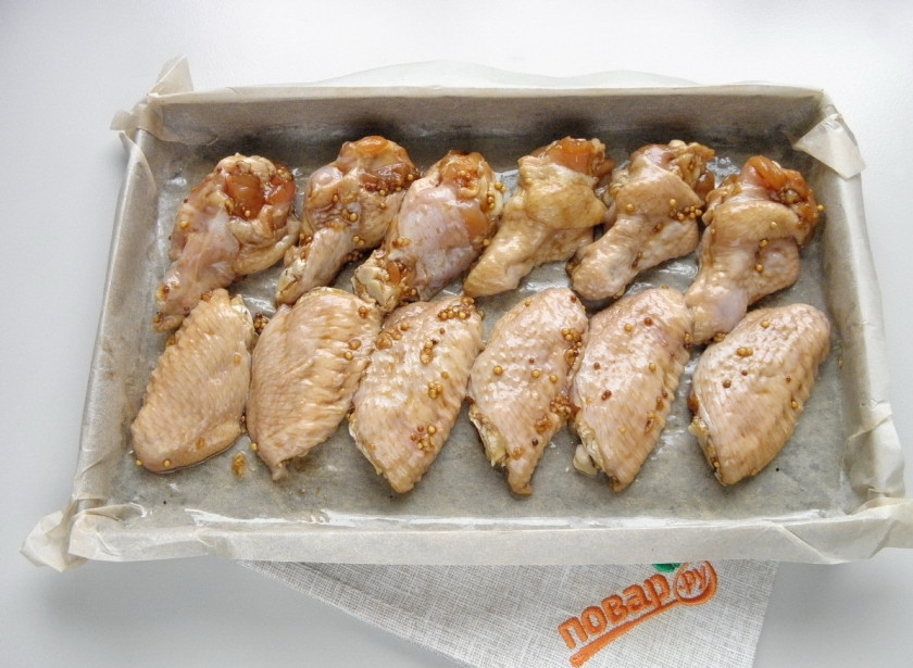 1. Этап. Острые крылышки к пиву: Через 2 часа откиньте крылышки на дуршлаг, пусть стечет жидкость. Я стараюсь убрать чеснок, потому как он горит в духовке. Застелите противень бумагой, смажьте его маслом рафинированным, разложите крылышки не слишком плотно. Отправьте противень в горячую духовку на 35-40 минут, температура — 200 градусов.