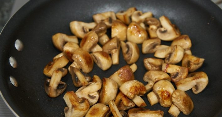 1. Этап. Бефстроганов (классический рецепт): 3. Верните сковороду на огонь и выложите сливочное масло, нарежьте небольшие грибы на 4 части и выложите в сковороду, обжаривайте до испарения жидкости.