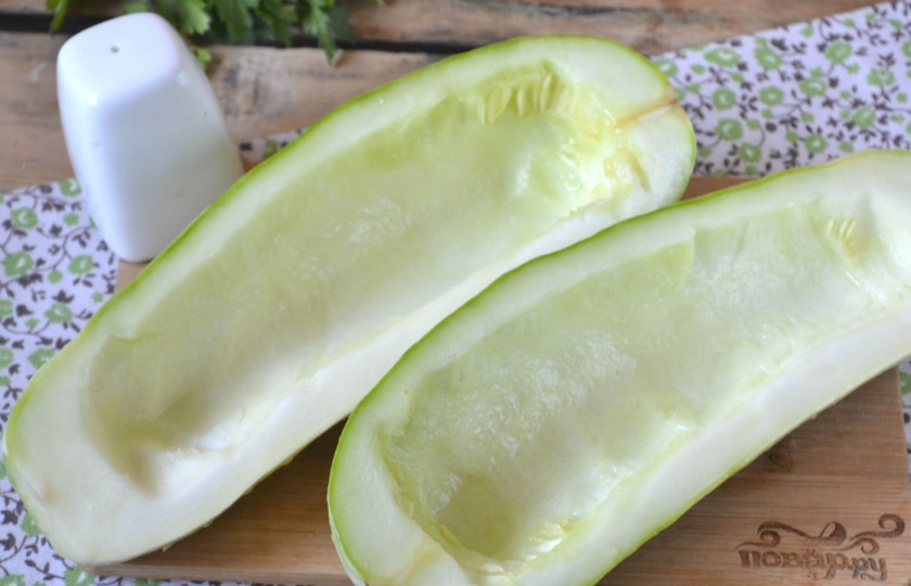 1. Этап. Кабачки в духовке с фаршем: Каждый кабачок разрежьте пополам. Ложкой вычистите середину с семечками, чтобы образовалась лодочка.