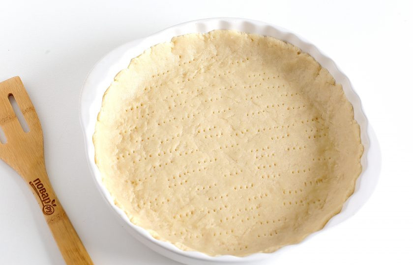 1. Этап. Песочный пирог: Разделите тесто на две неравные части. Ту часть, что поменьше, заверните и уберите пока в холодильник. Вторую часть раскатайте и переложите аккуратно в смазанную маслом форму. Руками придайте ему нужный размер и сформируйте бортики. Дно наколите вилкой.