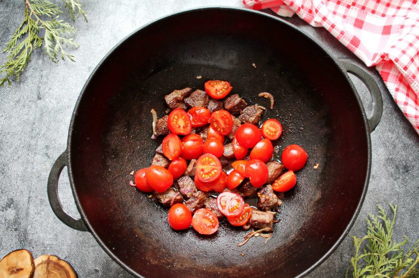 1. Этап. Кебоб по-бухарски: Добавьте в казан нарезанные помидоры и обжаривайте еще 5 минут.