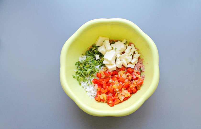 1. Этап. Голубцы в стеблях лука порея: Добавьте в миску обжаренные овощи, нарезанную зелень и порезанный мелким кубиком плавленый сырок. Все посолите, поперчите и хорошо перемешайте.