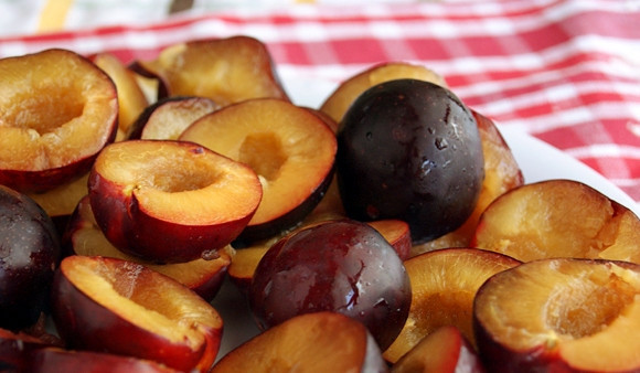 1. Этап. Сливовый пирог перевертыш: 4. Тщательно моем фрукты. Раскалываем сливы на половинки и удаляем косточку.