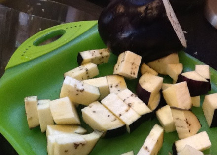 1. Этап. Баклажаны, тушеные с овощами: Сначала нужно очистить и нарезать все овощи, не забывая их промыть. Баклажан от кожуры чистить не обязательно, поскольку тот может потерять форму. Нарезаем его на крупные кубики. Перчики очищаем от семечек и нарезаем их дольками. С цуккини поступаем точно также как и с баклажаном. А вот помидоры лучше избавить от кожуры, для этого делаем небольшой надрез и на кожуре и опускаем его на минутку в кипяток. После этого также крупно его нарезаем и присоединяем к остальным овощам. Лук очищаем от шелухи, нарезаем его полукольцами и отправляем к его собратьям по грядке.