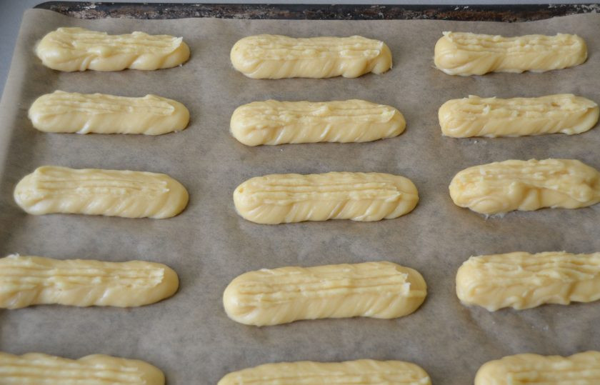 1. Этап. Глазурь для эклеров: Отсадите эклеры на лист пергамента, вилкой сделайте бороздки.