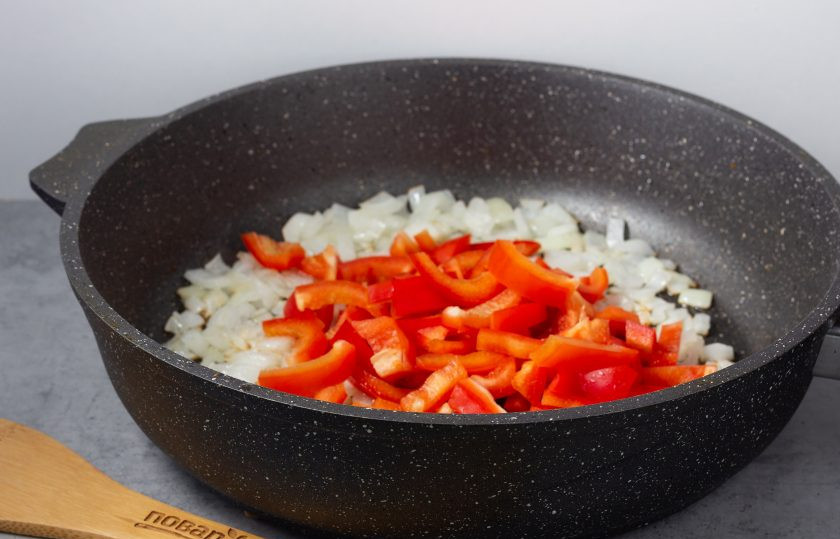 1. Этап. Теплый салат со стручковой фасолью и курицей: В этой же сковороде обжарьте нарезанный лук, затем добавьте нарезанный брусочками перец.