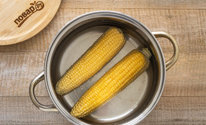 1. Этап. Варёная кукуруза со сливочным маслом: Переложите в большую кастрюлю, влейте холодную воду. Доведите до кипения, убавьте температуру и варите полчаса. Чтобы початки не всплывали, положите сверху тарелку в качестве груза.