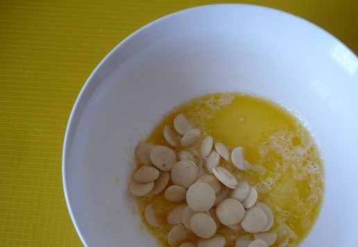 1. Этап. Творожный десерт: Нагрейте молоко и сливочное масло, так, чтобы они стали горячими и масло растопилось. В горячее молоко высыпать измельчённый белый шоколад (у меня шоколад в гранулах). Шоколад должен быть полностью покрыт молоком. Подождите две – три минуты, что бы он растаял, и тщательно перемешайте венчиком до однородного состояния.