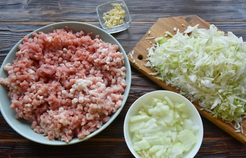 1. Этап. Пигоди по-корейски: Пока тесто отдыхает, приготовьте начинку для пигоди. Свинину перекрутите на мясорубке с крупной решеткой. Капусту нашинкуйте соломкой. Лук нарежьте мелким кубиком. Измельчите чеснок.