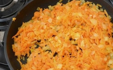 1. Этап. Печеночный торт из говяжьей печени: Чистим лук и морковку. Лук нарезаем мелкими кубиками, морковь натираем на терке. Обжариваем лук с морковкой на растительном масле до готовности. Не лейте много масла - начинка получится слишком жирной. Лучше жарить-тушить на небольшом огне и под крышкой.