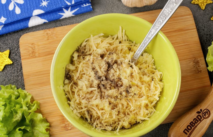 1. Этап. Фаршированные яйца Глаз дракона: Добавьте к измельчённым желткам тёртый на мелкой тёрке сыр и давленые зубчики чеснока. Посолите и поперчите начинку по вкусу.