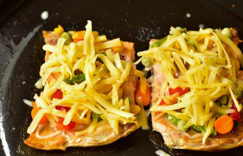 1. Этап. Горбуша с мексиканской смесью в духовке: Отправьте рыбу в разогретую до 190 градусов духовку на 20 минут. После этого выложите на каждый кусок рыбы тертый сыр.